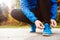 Unrecognizable runner crouching, tying shoelaces, close up