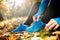 Unrecognizable runner sitting on the ground, tying shoelaces, au