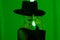 Unrecognizable sexy woman runs finger across brim of hat in dark neon studio background with colored green light. Femme