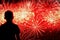 Unrecognizable silhouette of a child with his back to us, which looks spectacular show Fireworks. Festive background