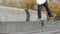 Unrecognizable skater doing trick nose slide to fakie on the street ledge