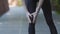 Unrecognizable slim athletic woman in black leggings female runner jogger athlete having painful knee injury during