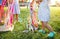 Unrecognizable small girls outdoors in garden in summer, playing with rainbow hand kite.