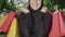Unrecognizable smiling woman in black hijab holding shopping bags in hands and smiling. Portrait of young Middle Eastern