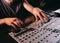 Unrecognizable sound producer or engineer rotates scrolls wheel on mixing console in professional recording studio