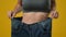 Unrecognizable sport woman in large big size jeans. Close up female strong abdominal tummy slim slender thin body waist