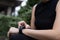 Unrecognizable sporty women in sports wear raise hand and use finger to adjust setting application in smartwatch on wrist to