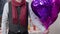 Unrecognizable stylish Caucasian man in vest shirt and scarf holding balloons standing indoors. Romantic loving husband