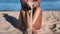 Unrecognizable tanned woman in swimsuit pouring sand grains at summer beach coastline slow motion