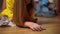 Unrecognizable teen girl stacking coins on floor in living room at home. Adolescent Caucasian shopper gathering money