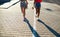 Unrecognizable teenager girls friends with skateboards walking outdoors in city.