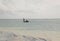 Unrecognizable three Kenyan fishermen in the distance in a boat with a long oar went fishing