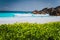 Unrecognizable tourist dabble in blue colored waves at Grand Anse beach, La Digue Island, Seychelles