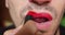 Unrecognizable transgender man rouging lips