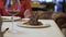 Unrecognizable waiter serving big plate with roasted ribs with grilled vegetables close up. Man and woman having a date