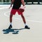 Unrecognizable white Caucasian skinned man plays basketball on a basketball court in a urban street