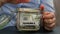 Unrecognizable woman add money to Saving Money In Glass Jar filled with Dollars banknotes. INSURANCE transcription in