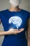 Unrecognizable woman in blue clothes holding highlighted handrawn Brain in hands. Medical illustration, template, science mockup