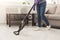 Unrecognizable woman cleaning house with vacuum cleaner