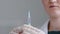 Unrecognizable woman doctor nurse medical worker scientist wears latex gloves holds syringe with needle in hands