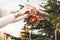 Unrecognizable woman hand putting an ornament on the Christmas tree