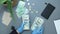 Unrecognizable woman hands in protective gloves with pile of money, counting US dollars bills. Top view of office table. Accountan