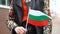 Unrecognizable woman holding Bulgarian flag. Girl walking down street with national flag of Bulgaria