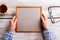 Unrecognizable woman holding empty picture frame, studio shot.