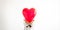 unrecognizable woman holding heart shaped ballon in front of his head, against white background in white sweater. Happy valentines
