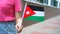 Unrecognizable woman holding Jordanian flag. Girl walking down street with national flag of Jordan