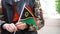 Unrecognizable woman holding Vanuatu flag. Girl walking down street with national flag of Vanuatu