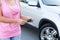 Unrecognizable woman with ignition key standing near own vehicle