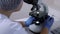 Unrecognizable woman laboratory technician conducts medical test use microscope.