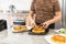 Unrecognizable woman plating cereal battered fried chicken over waffles and syrup