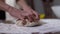 Unrecognizable woman pouring flour on pastry dough. Caucasian female adult hands and little male palms kneading raw