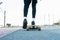 Unrecognizable woman rides on longboard around sunlit park