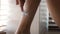 Unrecognizable Woman Shaving Legs In Modern Bathroom, Closeup