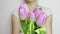 Unrecognizable woman showing a bouquet of spring flowers, lilac tulips close up - 8 march, Valentine day or mother`s day