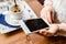 Unrecognizable woman with smartphone in cafe drinking coffee