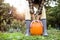 Unrecognizable woman in striped rubber boots holding orange pump