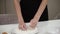 Unrecognizable woman takes a handful of flour from a plate lets it fall, fray through .Closeup of hands,slow motion