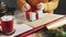 Unrecognizable Woman Unwrapping Christmas Presents On Table With Christmas Decoration.