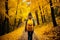 Unrecognizable woman walking on autumn forest path, active outdoor nature walk in the woods