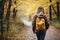 Unrecognizable woman walking on autumn forest path with beautiful woods in background