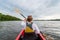 Unrecognizable Young girl kayaking on a river or lake. Happy girl canoeing on a summer day.