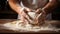 Unrecognizable young man kneading dough on wooden table. Males hands making bread on dark background. Selective focus.