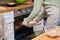 Unrecognizable young woman putting into the oven stuffed aubergines