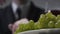 Unrecognized businessman eating grapes close-up.