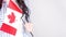 Unrecognized girl student in white blue shirt holding small canadian flag over gray background, Canada day, holiday, vote,