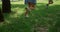 Unrecognized kid legs run on green lawn. Happy children play on fresh grass.